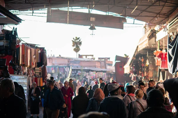 Marrakech, Marruecos - Enero 2019: Multitud de personas paseando por el gran mercado callejero del zoco a través de la famosa plaza Jemaa el-Fnaa — Foto de Stock