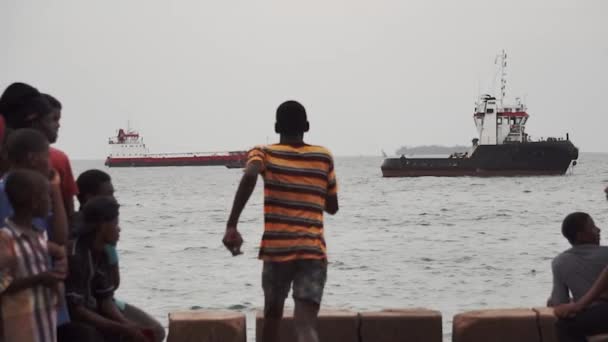 ZANZIBAR, STONE TOWN - JANUARI 2020: Varje dag High Tide Zanzibar Routine - svarta afrikanska pojkar hoppar i havet vatten från stenutsättning och ha kul — Stockvideo