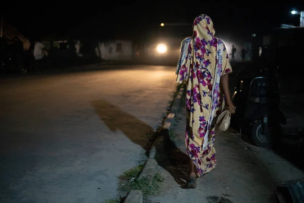 Woman Walking at night Along the Road in Traditional Muslim Women Cloth in Zanzibar, Tanzania