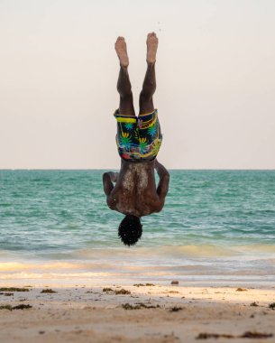 Beyaz Kum Sahili Akrobatik Eğitimi ve Atlayan Jimnastik Sahili Performansında Genç Çekici Kaslı ve Güçlü Siyah Afrikalı Adam