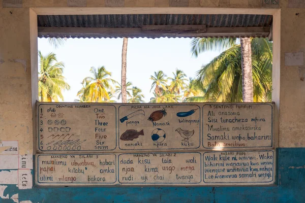 Una clase ordinaria en una escuela africana. Las paredes están pintadas con escritorios informativos — Foto de Stock