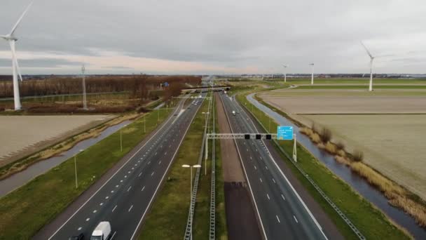 Fila de aerogeneradores en los Países Bajos en el día nublado en una autopista de vehículos Amsterdam - Rotterdam . — Vídeo de stock