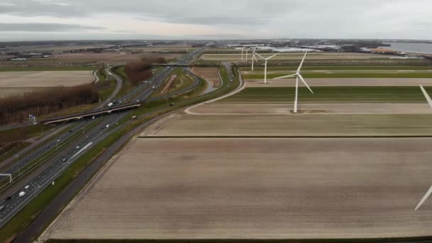 Rij windturbines in Nederland op een bewolkte dag op een autoweg Amsterdam - Rotterdam. — Stockvideo