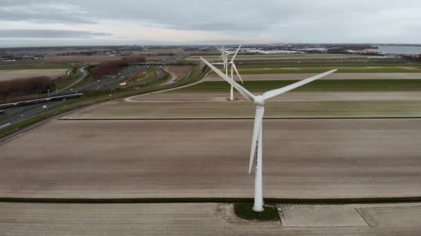 Fila de aerogeneradores en los Países Bajos en el día nublado en una autopista de vehículos Amsterdam - Rotterdam . — Vídeo de stock