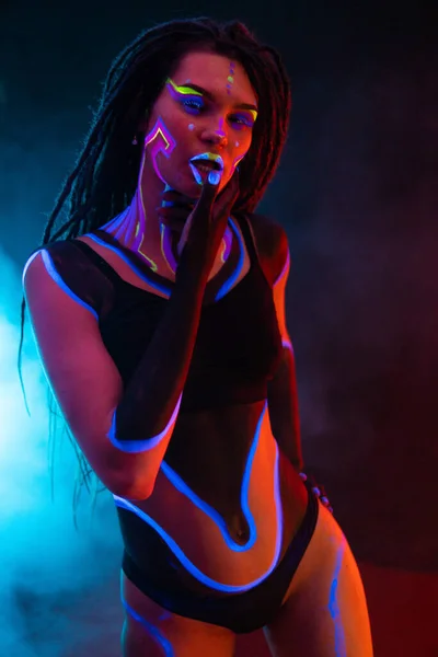 Cocky Girl with Dreadlocks in Ultraviolet νέον φως με ομιχλώδες φόντο. Bodyart — Φωτογραφία Αρχείου