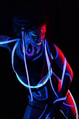 Neon UF Işık 'ta Parlayan Tüplü Warror Girl' ün Portresi. Dreadlocks ve Flüoresan Yaratıcı Psikedelik Makyaj, UV 'deki Kadın Disko Dansçısı Sanat Tasarımı, Renkli Soyut