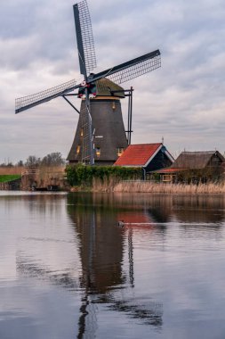Kinderdijk Holland 'daki ünlü yel değirmenlerinin üzerinde dramatik bulutlu bir gökyüzü. Güneşli bir yaz akşamı, yel değirmeni köyünün kırsalında. Hollanda, UNESCO Dünya Mirası Bölgesi. Kinderdijk Yel Değirmeni Köyü
