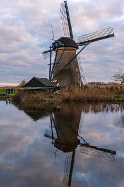 Kinderdijk Holland 'daki ünlü yel değirmenlerinin üzerinde dramatik bulutlu bir gökyüzü. Güneşli bir yaz akşamı, yel değirmeni köyünün kırsalında. Hollanda, UNESCO Dünya Mirası Bölgesi. Kinderdijk Yel Değirmeni Köyü