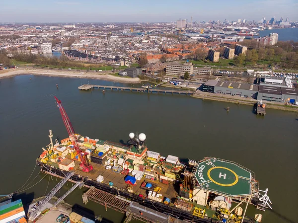 Schiedam, Hollanda - Mart 2020: Nieuwe Maas 'taki Voorhaven of Schiedam rıhtımından dev bir Crane gemisiyle limanın havadan çekimi