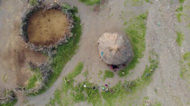 Günbatımında Afrika 'nın kuzey Tanzanya bölgesindeki Arusha Bölgesi' nde Engare Sero köyü Maasai dilinde Tanrı 'nın Dağı Ol Doinyo Lengai' nin önündeki Maasai köyü üzerinde Uçan Sinek Manzarası.