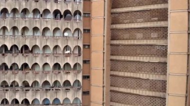 Yatırım Evi 'nin Hava Aracı Çekimi - Dar es Salaam, Tanzanya' da yay panelli garip beton üçgen yüksek bina.