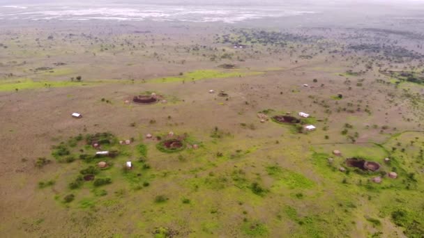 空中フライバイビューマサイー語で神の山、オルDoinyo Lengaiの前のナトロン湖の海岸にあるマサイー村、 Arusha地域のEngare Sero村i北部 — ストック動画
