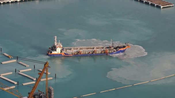 DUBAI, Förenade Arabemiraten - the Suction Mudger vessel in Dubai, Persiska viken. Sug Mudderfartyg öppnade dammluckorna med lera, Föroreningar, brunt lerigt vatten - antenn skott — Stockvideo