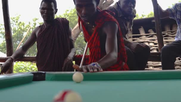 Lake Natron, Tanzania jan 2020: Afrikanske masai mænd spiller udendørs billard pool i landsbyen Engare Sero på Masailand – Stock-video