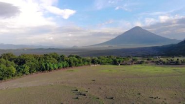 Ol Doinyo Lengai 'nin önündeki Maasai köyündeki Koyun Sürüsü' nün Havadan görünüşü - Maasai dilinde Tanrı 'nın Dağı, Arusha bölgesinde aktif bir yanardağ, Kuzey Tanzanya, Afrika, Sunset
