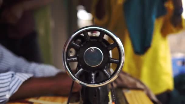 Máquina de coser en remota aldea africana. Mano del hombre africano mayor en una rueda de coser. — Vídeo de stock