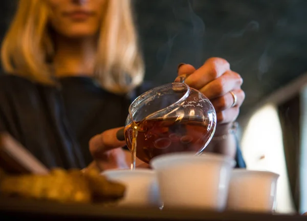 伝統的な中国茶の儀式。黒または赤茶注ぎによってaブロンドカキア人の女の子にホワイトペアカップ上のダークテーブル背景 — ストック写真