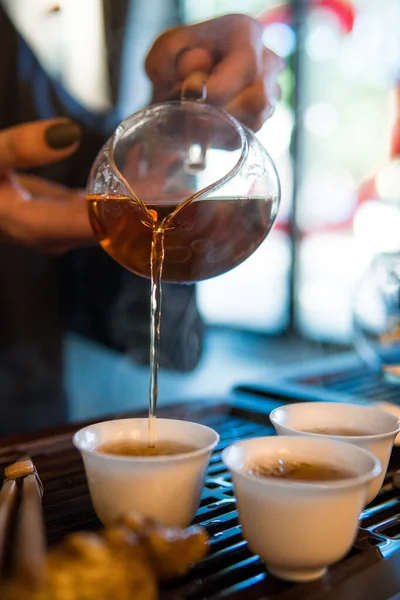 Традиционная китайская чайная церемония. Черный или красный чай наливая в белый pial чашку на темном фоне стола — стоковое фото
