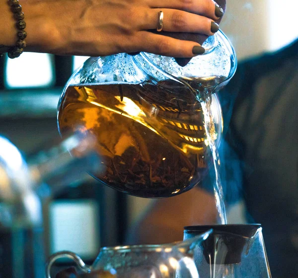 Ceremonia tradicional del té chino. Té negro o rojo que vierte de la tetera grande de cristal en el Chahai de cristal en el fondo oscuro de la tabla de madera —  Fotos de Stock