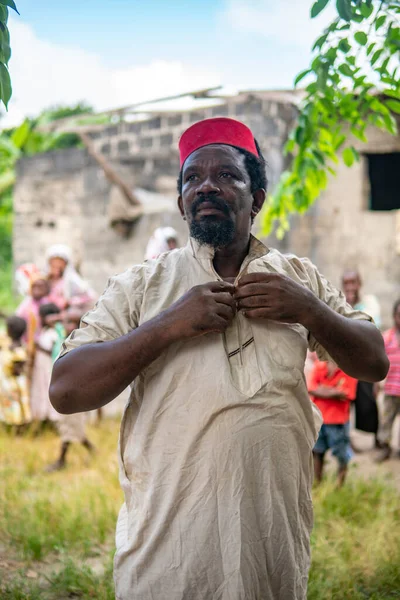 Um homem mais velho africano, o prefeito de sua aldeia em vermelho muçulmano chapéu Taqiyyah e vestido branco. Pequena aldeia remota na Tanzânia, ilha de Pemba, arquipélago de Zanzibar — Fotografia de Stock