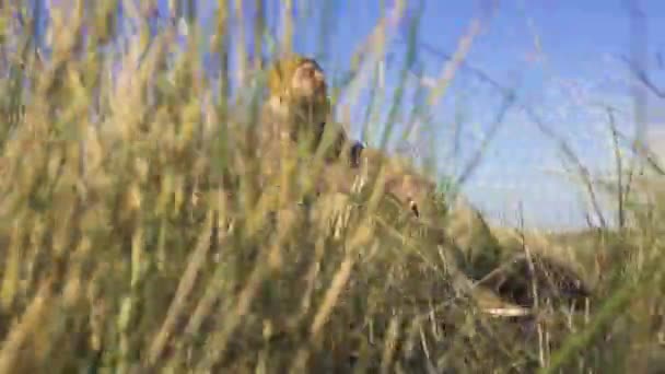 Slow Motion Beauty Shot of Serious Bearded man in Yellow Hat sentado na grama alta. Primavera do Outono Tempo nos Países Baixos — Vídeo de Stock