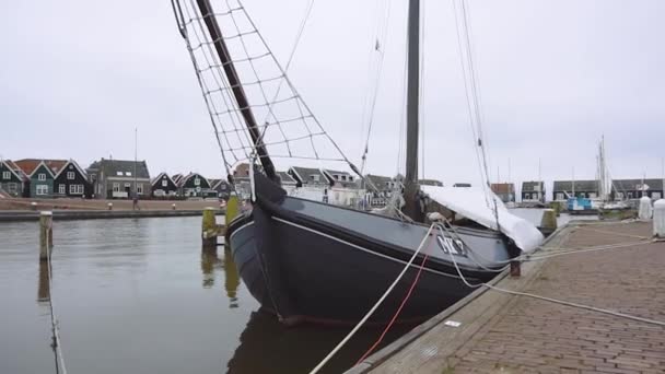 Traditionella holländska träbåtar vid molnigt vårväder förtöjs i Marken, Nederländerna. Eluttag för att ladda fartyg i hamn — Stockvideo