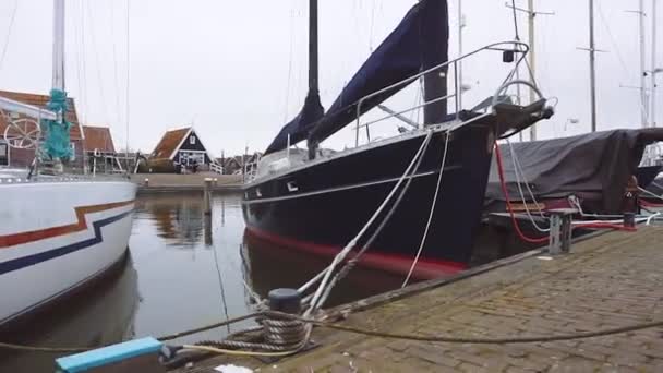 Tradiční holandská dřevěná jachta je nabíjení v Marken, Nizozemsko. Elektrické zásuvky pro nabíjení lodí v přístavu