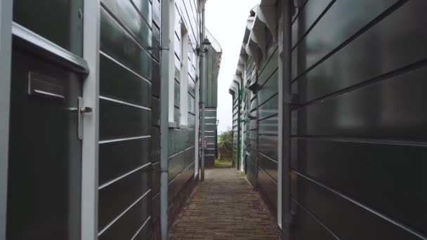 Door POV Shot van een extreem smalle passage in Marken, Nederland. Traditionele Hollandse Houten Huizen Omgeving strakke Straat in Bewolkte Misty Day — Stockvideo