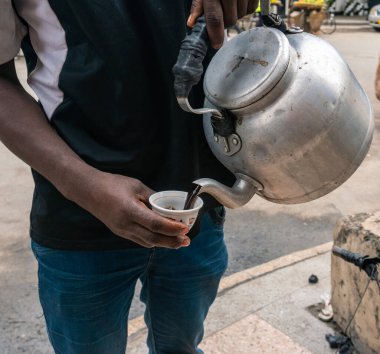 Siyah Afrikalı Adam Dar es Salaam, Tanzanya, Afrika 'da küçük bir fincana kahve döküyor.