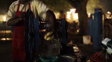 Taş Kent, ZANZIBAR - Ocak 2020: Kara Afrikalı bir adam el yapımı meyve sıkacağıyla taze, organik meyve suyu yapmak için Forodhani Gece Pazarı 'nda şeker kamışı sıkar. Zanzibar 'dan sağlıklı ürün