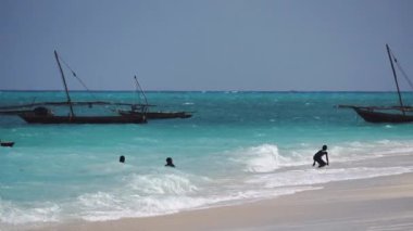 Nungwi, Zanzibar - Aralık 2019: Turkuaz Suda Siyah Afrikalı Çocuklar. Kuzey Zanzibar 'daki Nungwi köyünde Sunny Day' de Okyanus Dalgaları 'nda oynayan Afrikalı çocuklar.
