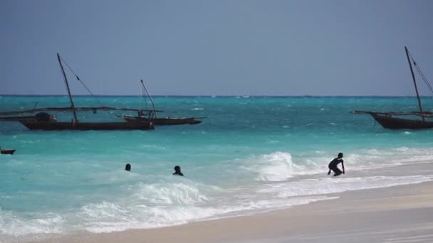 Nungwi, Zanzibar - 2019 년 12 월 : Black African Boys in Turquoise Water. 탄자니아 잔지바르 북부응 위 마을의 순니 데이에 있는 아프리카 어린이들, 해변에서 노는 모습 — 비디오