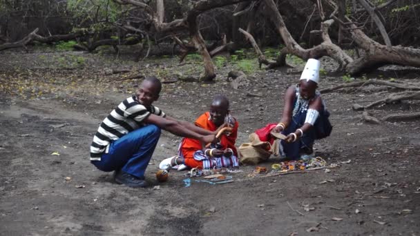 TANZANIA, MASAI VILLAGE - ΙΑΝΟΥΑΡΙΟΣ 2020: Άνθρωποι Maasai πωλούν χάντρες Bijou στο γηγενές χωριό Masai Engare Sero στην ακτή της λίμνης Natron στην κοιλάδα Rift στην Ταϊλάνδη, περιφέρεια Arusha — Αρχείο Βίντεο