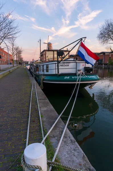 Twilight efter solnedgången skott av högsta väderkvarn i världen och Vessel på förgrunden i Schiedam, Nederländerna är känd för sina väderkvarnar och även JWhen, en typ av gin — Stockfoto