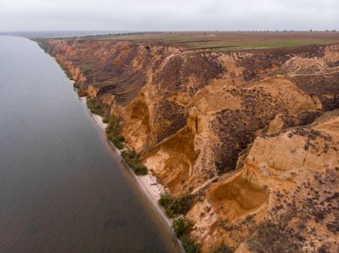 Sisli sonbahar havasında Karadeniz yakınlarında kil tepelerin ve kanyonların havadan çekilmiş görüntüleri. Stanislavlar dağları, Kherson bölgesi, Ukrayna