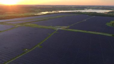 Photovoltaik Panelleri olan güneş enerjisini elektriğe çeviren bir güneş çiftliği. Günbatımında Danimarka 'da yeşil enerji. Havadan. Yüksek kalite 4k görüntü