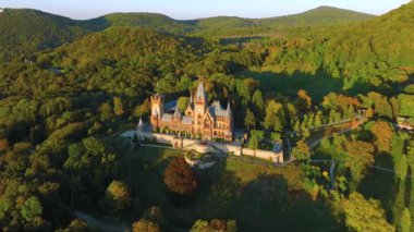 Drachenburg Siebengebirge kalesinin hava görüntüsü gün batımında Nord-Rhein Westfell 'de Bonn yakınlarında. Konigswinter Yüksek kalite 4K görüntü