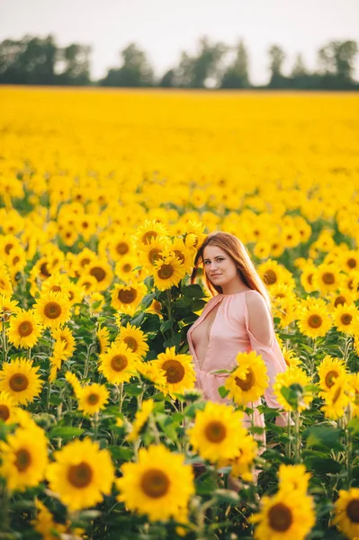 Beautiful girl in a huge yellow field of sunflowers. — Stock Photo, Image