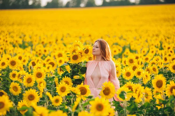 Schöne Mädchen in einem riesigen gelben Feld von Sonnenblumen. — Stockfoto