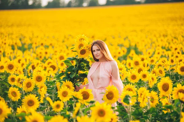 Menina bonita em um enorme campo amarelo de girassóis . — Fotografia de Stock