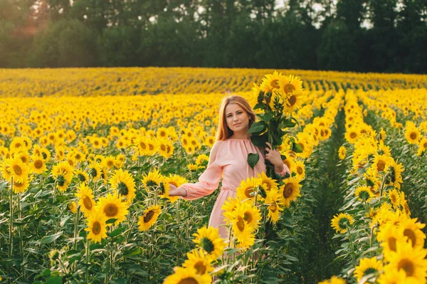 Beautiful girl in a huge yellow field of sunflowers. — Stock Photo, Image