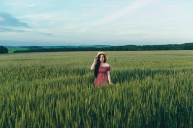 Alanında gün batımında güzel genç kadın