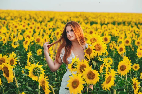 Ayçiçeği büyük bir sarı alanda güzel kız. 