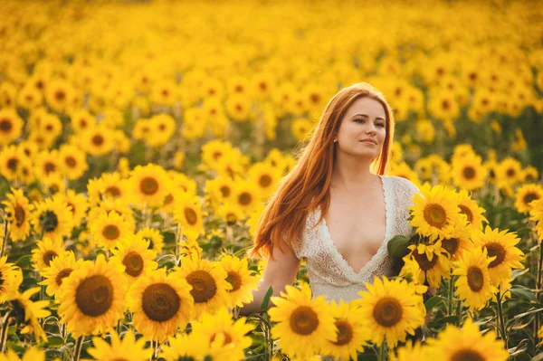 Beautiful girl in a huge yellow field of sunflowers. — Stock Photo, Image