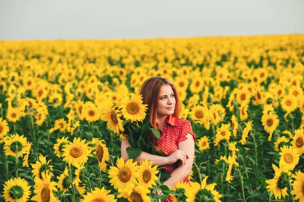 Beautiful girl in a huge yellow field of sunflowers. — Stock Photo, Image