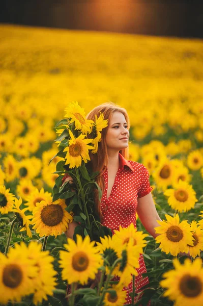 Schöne Mädchen in einem riesigen gelben Feld von Sonnenblumen. — Stockfoto