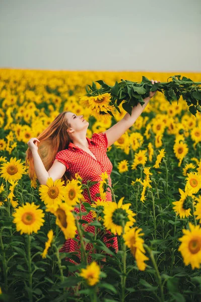 Beautiful girl in a huge yellow field of sunflowers. — Stock Photo, Image