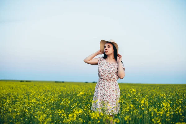 Beautiful young woman at sunset in the field — Stock Photo, Image