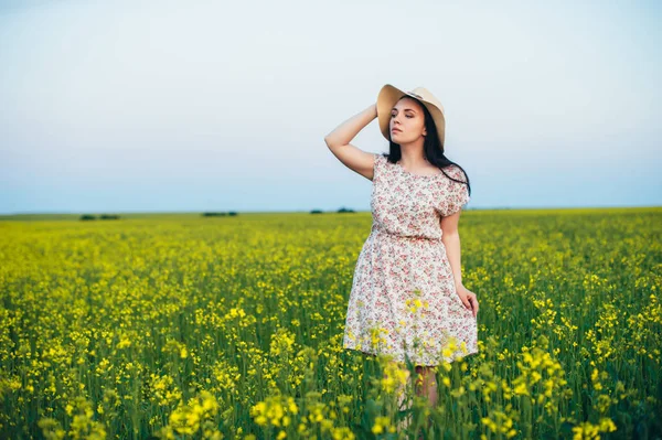 Beautiful young woman at sunset in the field — Stock Photo, Image