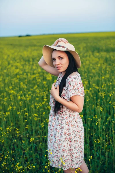 Vacker ung kvinna vid solnedgången på fältet — Stockfoto
